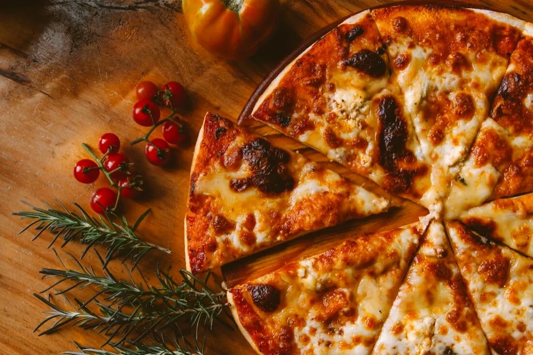 Knusprige Pizza mit geschmolzenem Käse, Tomaten und Kräutern