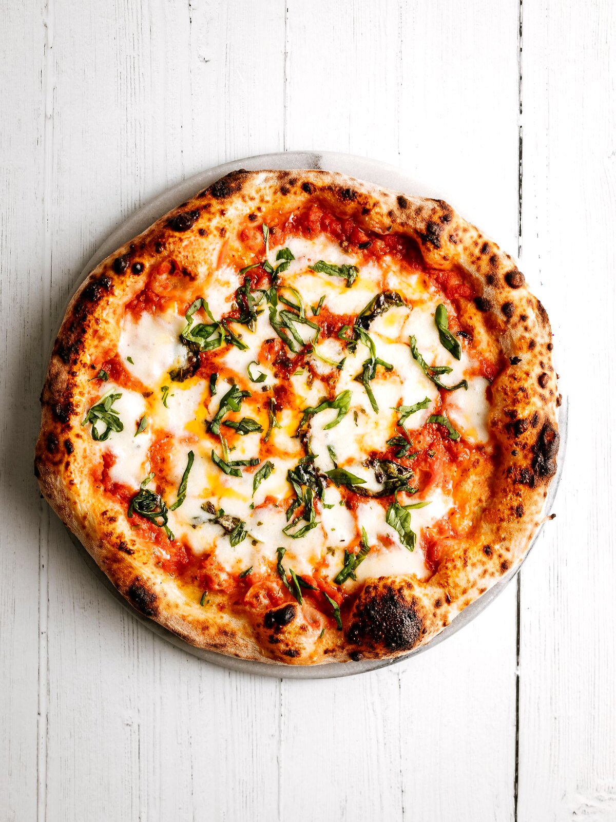 Frisch gebackene Pizza mit Basilikum und Tomaten