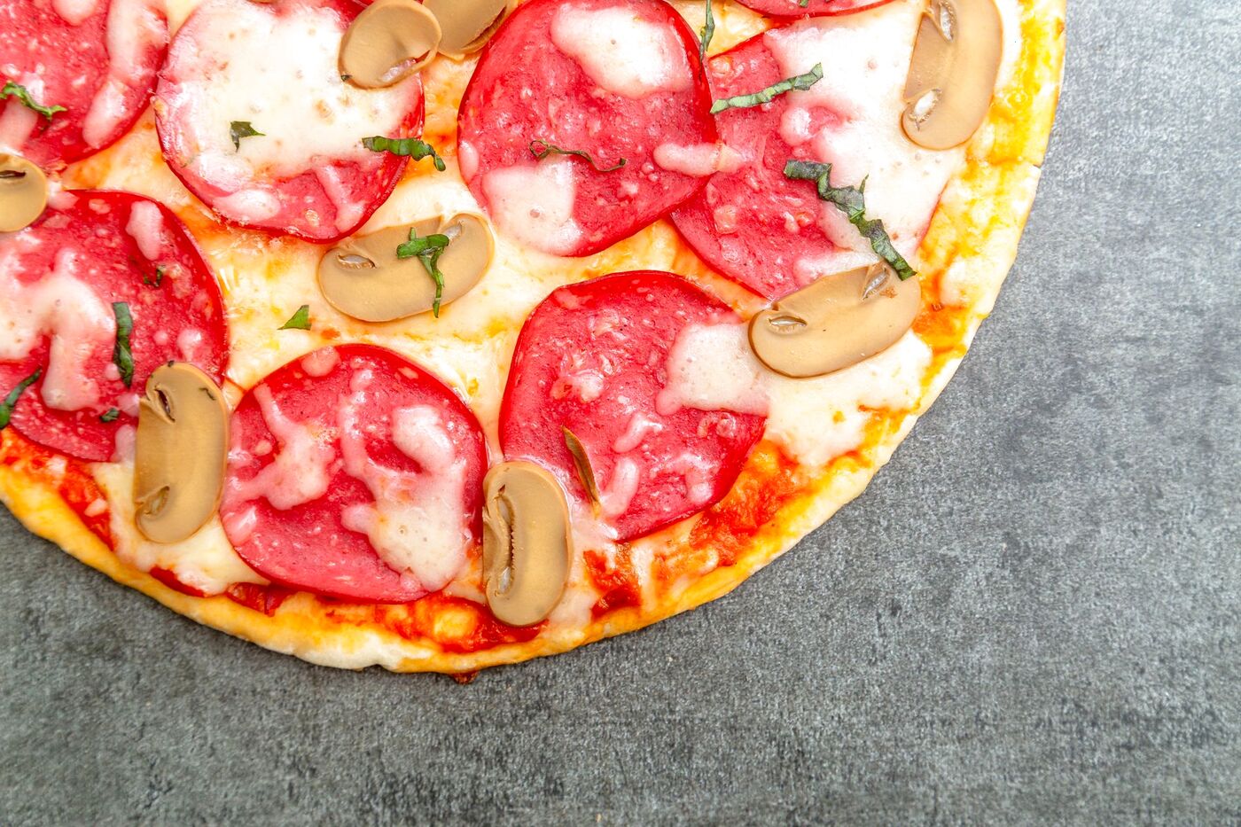 Pizza mit Salami, Champignons und Mozzarella von oben